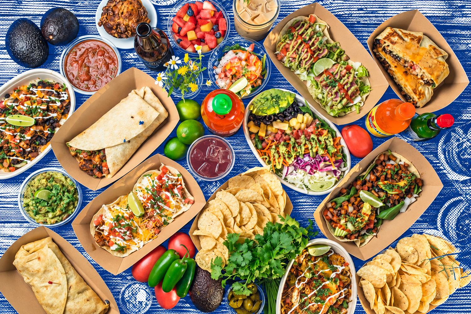 A Finns catering spread: burritos, tacos, bowls, chips, guac, salsa and ceviche on a table